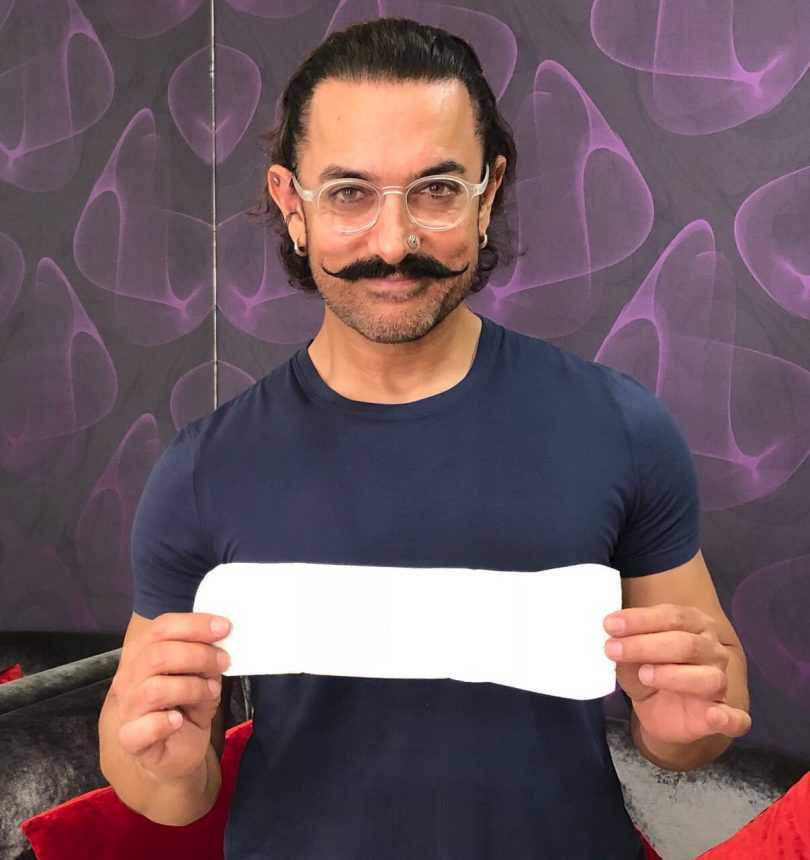 Aamir Khan stands with a sanitary pad in his hand to promote ‘ Padman’